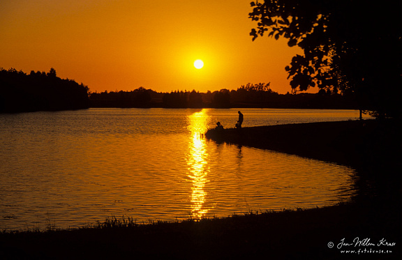Anglers at sunset at lake in local park Borgerswold (Veendam, The Netherlands)